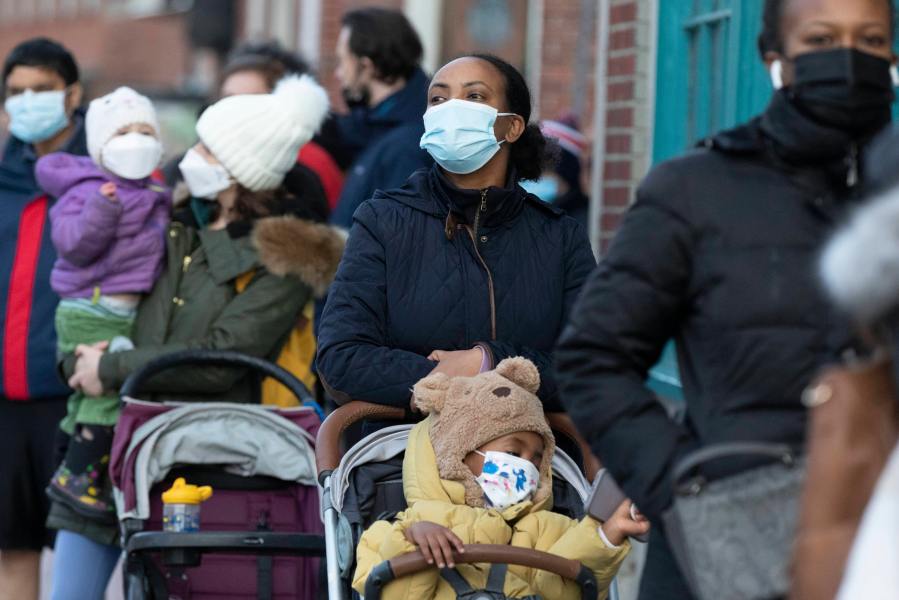 Makda Yesuf, center, and her son Jaden wait in line at a COVID-19 walk-in testing site on Dec. 5, 2021, in Cambridge, Mass. (AP Photo/Michael Dwyer, File)