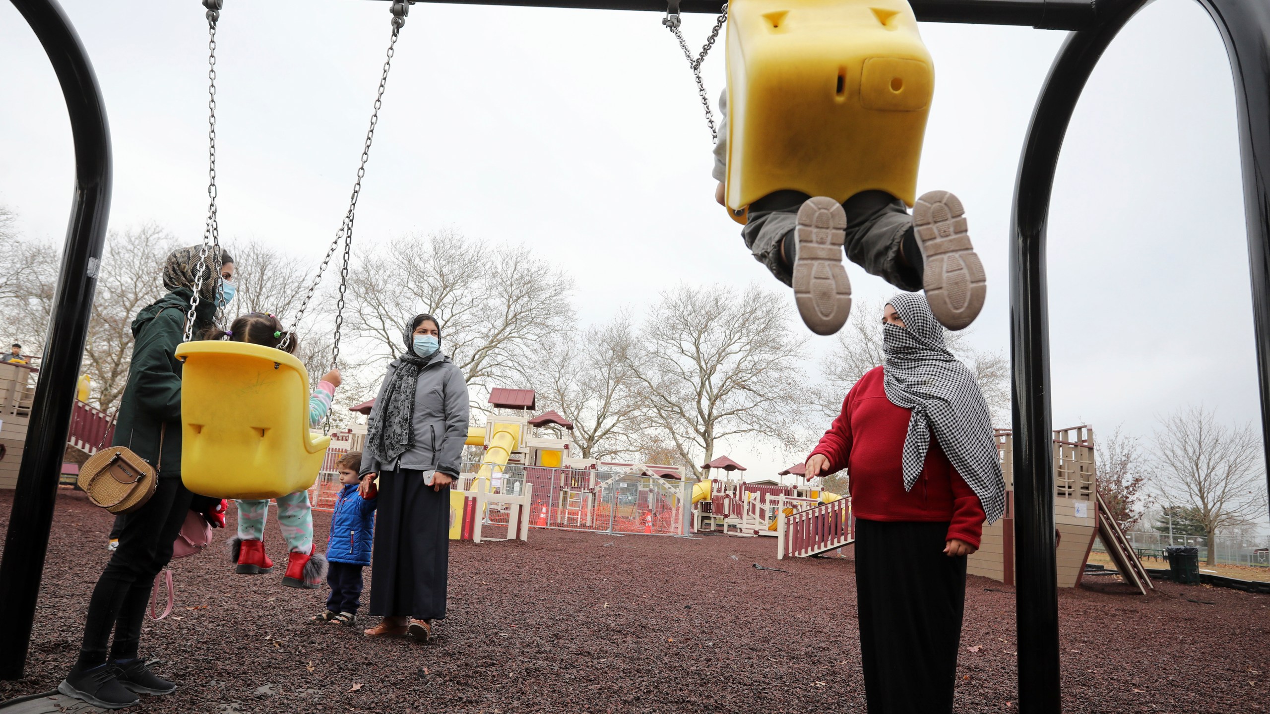 Afghan refugee mothers and children play in a park in Liberty Village on Joint Base McGuire-Dix- Lakehurst in Trenton, N.J., Thursday, Dec. 2, 2021. (Barbara Davidson/Pool via AP)