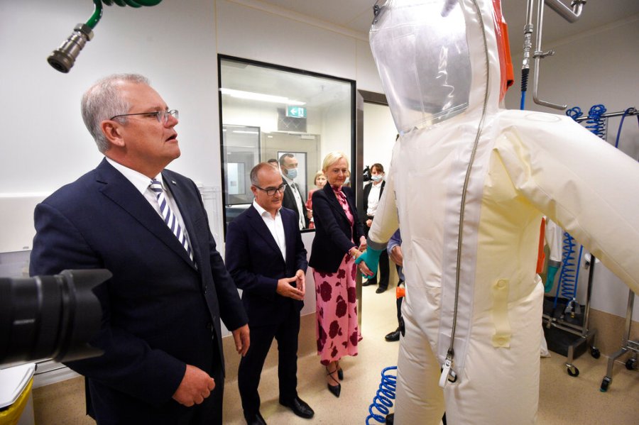 Australian Prime Minister Scott Morrison, left, looks at a hazard suit during a tour at the Peter Doherty Institute for Infection and Immunity in Melbourne, Tuesday, Dec. 14, 2021. (Andrew Henshaw/AAP Image via AP)