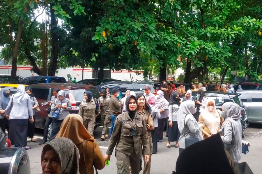 People wait outside after evacuating a government building following an earthquake in Makassar, South Sulawesi, Indonesia, Tuesday, Dec. 14, 2021. (AP Photo/Daeng Mansur)