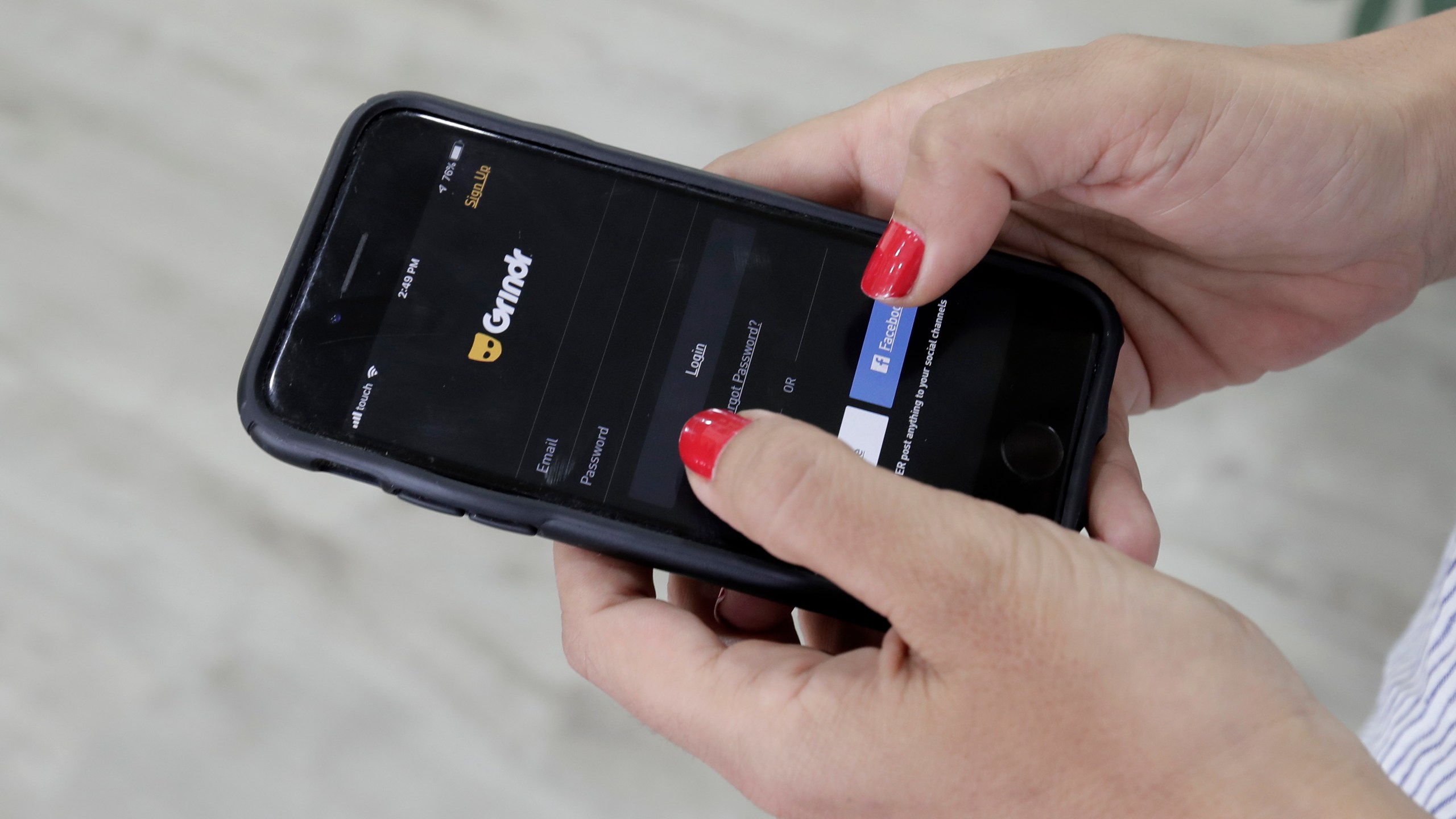 A woman looks at the Grindr app on her mobile phone in Beirut, Lebanon, May 29, 2019. Norway’s data privacy watchdog fined gay dating app Grindr $7.16 million for sending sensitive personal data to hundreds of potential advertising partners without users’ consent. The Norwegian Data Protection Authority said Wednesday, Dec. 15, 2021 that it imposed its highest fine to date because the California-based company didn’t comply with the European Union’s strict privacy rules. (AP Photo/Hassan Ammar, File)