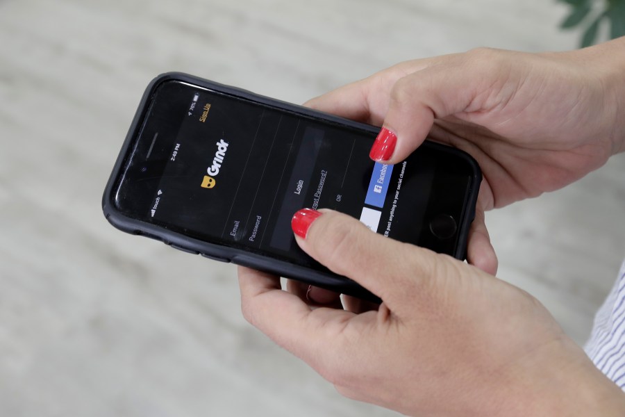 A woman looks at the Grindr app on her mobile phone in Beirut, Lebanon, May 29, 2019. Norway’s data privacy watchdog fined gay dating app Grindr $7.16 million for sending sensitive personal data to hundreds of potential advertising partners without users’ consent. The Norwegian Data Protection Authority said Wednesday, Dec. 15, 2021 that it imposed its highest fine to date because the California-based company didn’t comply with the European Union’s strict privacy rules. (AP Photo/Hassan Ammar, File)