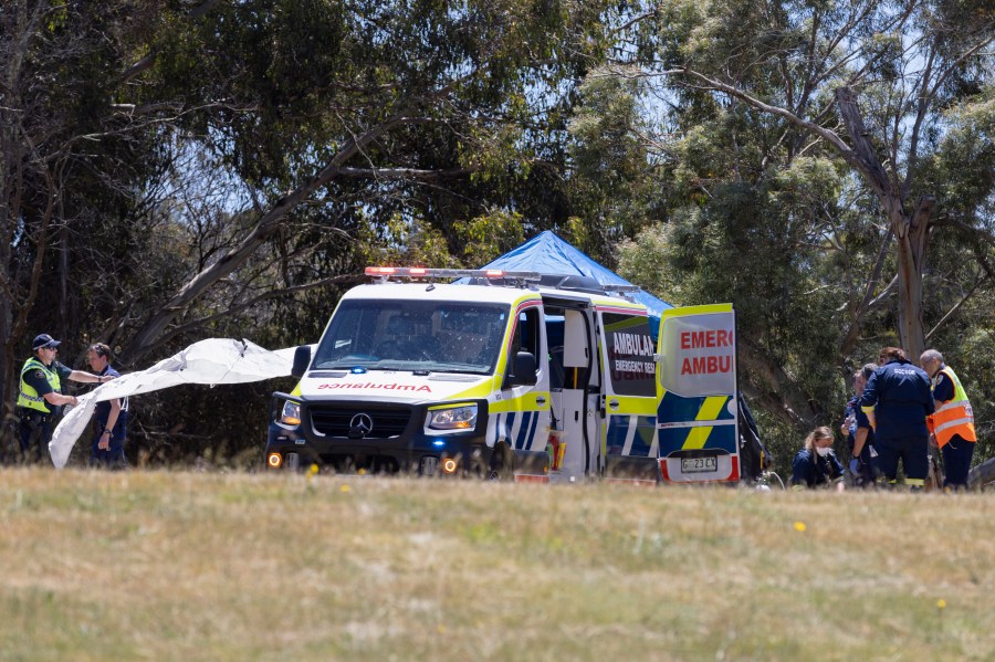 Emergency services personnel work the scene of a deadly incident involved with a bouncy castle at the Hillcrest Primary School in Devonport, Tasmania, Thursday, Dec. 16, 2021. Multiple children have died and others are in critical condition after falling from a bouncy castle that was lifted 10 meters (33 feet) into the air by a gust of wind at a junior school on the island state of Tasmania on Thursday. (Grant Wells/AAP Image via AP)