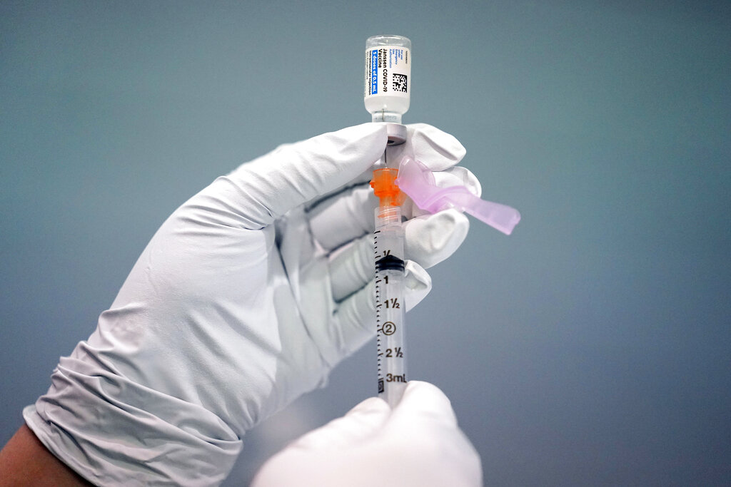 A member of the Philadelphia Fire Department prepares a dose of the Johnson & Johnson COVID-19 vaccine at a vaccination site setup in Philadelphia, on March 26, 2021. (AP Photo/Matt Rourke, File)