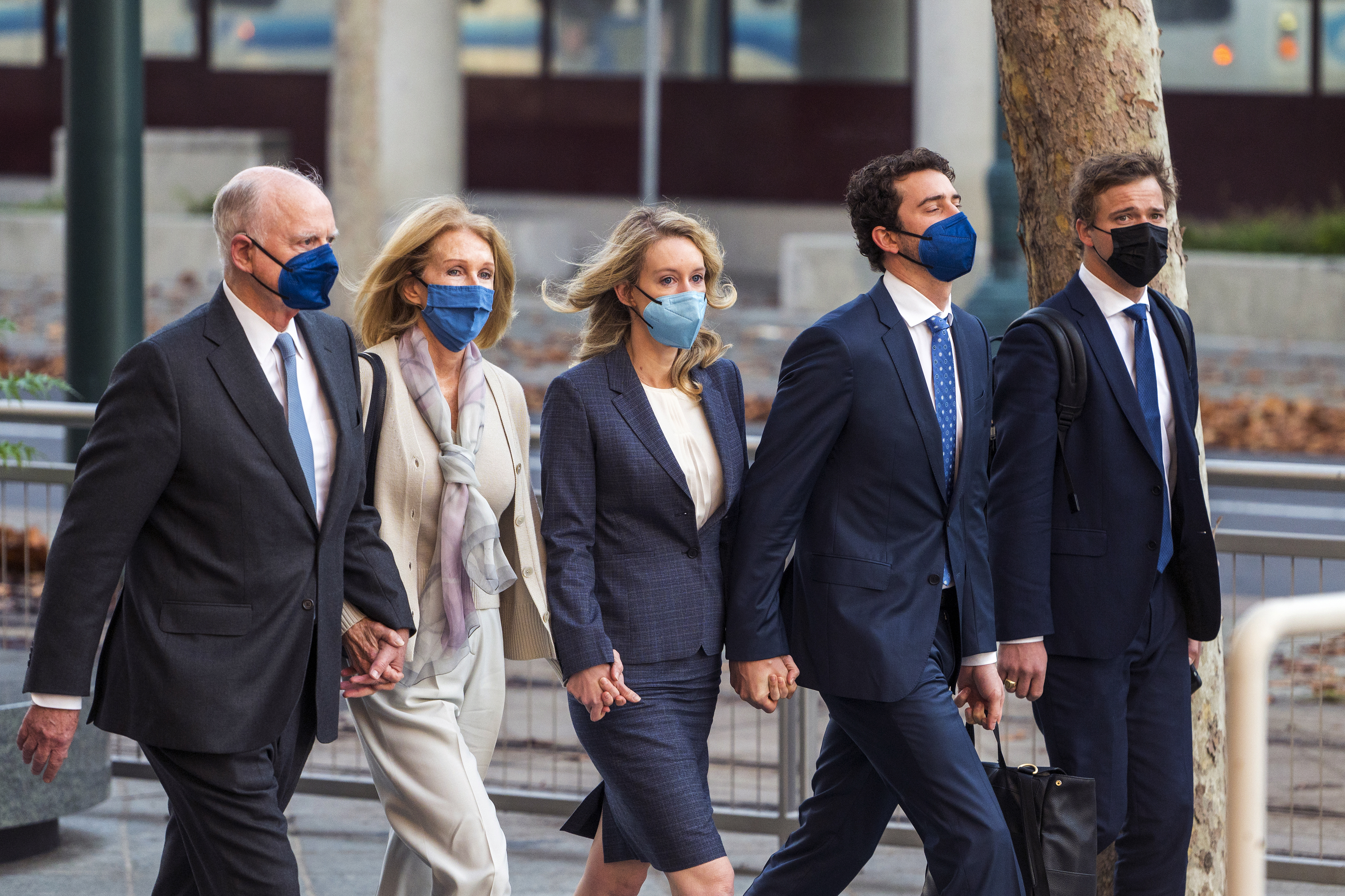 Elizabeth Holmes, center, walks into federal court in San Jose, Calif., Friday, Dec. 17, 2021. The lawyers for the opposing sides in the trial of former Theranos CEO are expected to wrap up their closing arguments Friday, paving the way for a jury to begin their deliberations over criminal charges accusing her of turning her blood-testing startup into a massive scam. (AP Photo/Nic Coury)