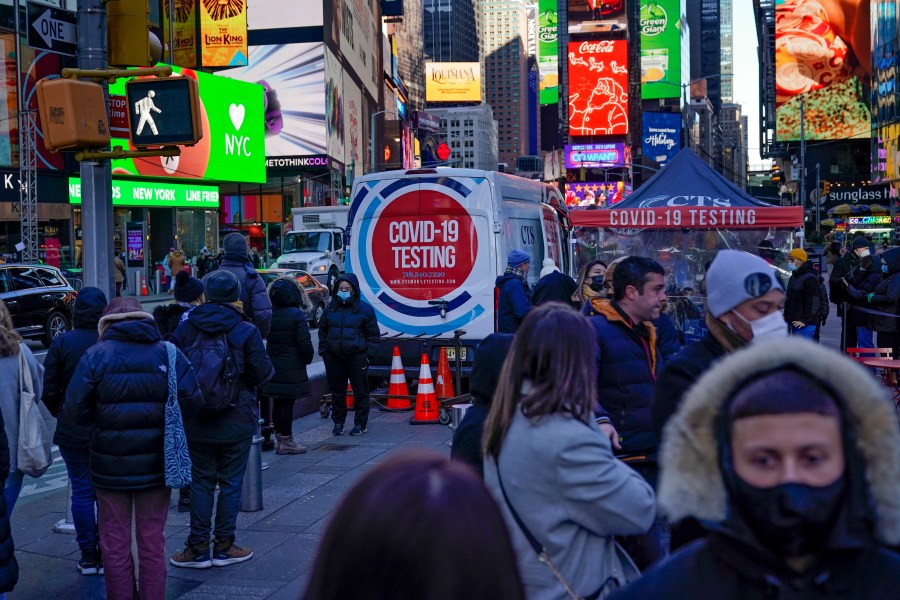 People wait in a long line to get tested for COVID-19 in Times Square in New York on Dec. 20, 2021. (AP Photo/Seth Wenig)