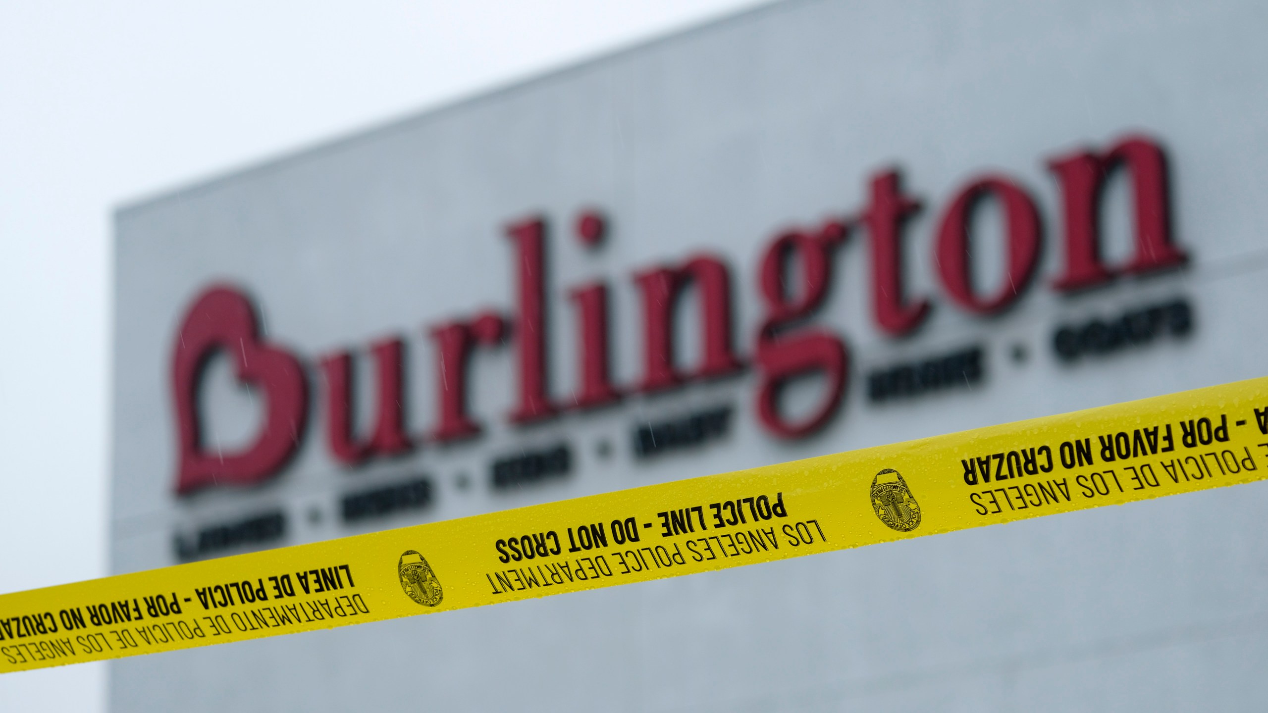 A police yellow tape is seen at the scene where two people were struck by gunfire in a shooting at the Burlington Coat Factory store in North Hollywood, Calif. on Dec. 23, 2021. (AP Photo/Ringo H.W. Chiu)