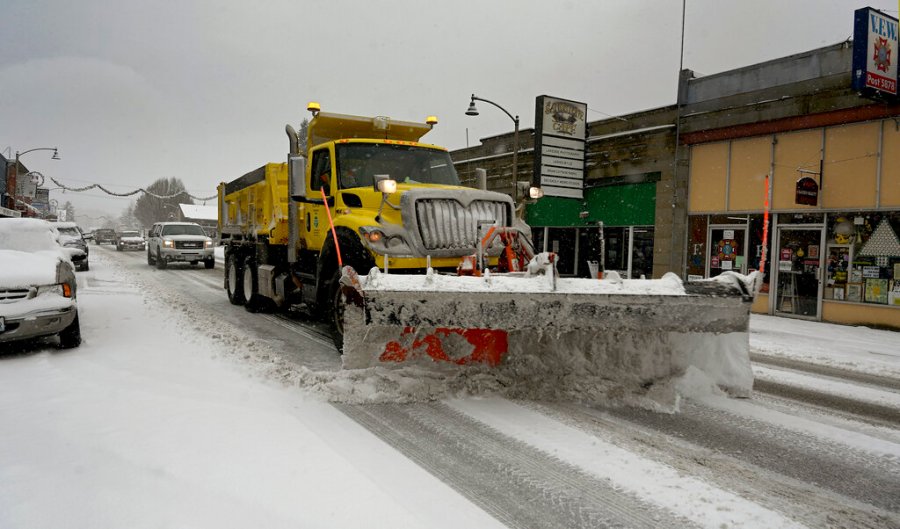 A snow plow travels down a street in Tenino, Wash. on Sunday, Dec. 26, 2021. (Steve Bloom/The Olympian via AP)