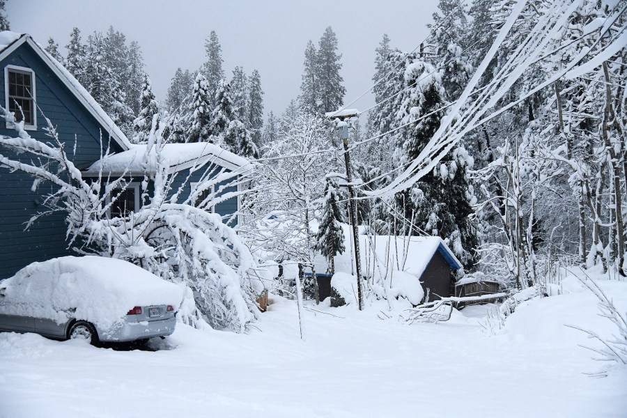 Spring Street in Nevada City, calif., was socked in with snow and downed tree limbs, on Monday, Dec. 27, 2021. (Elias Funez/The Union via AP)