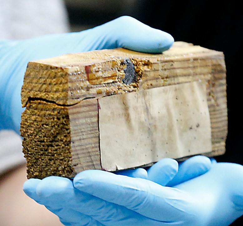 A block of wood with a bullet imbedded was one of the artifacts inside a copper box time capsule recovered from the base of a Robert E. Lee monument, Tuesday, Dec. 28, 2021, at the Virginia Department of Historical Resources lab in Richmond, Va. (Bob Brown/Richmond Times-Dispatch via AP)