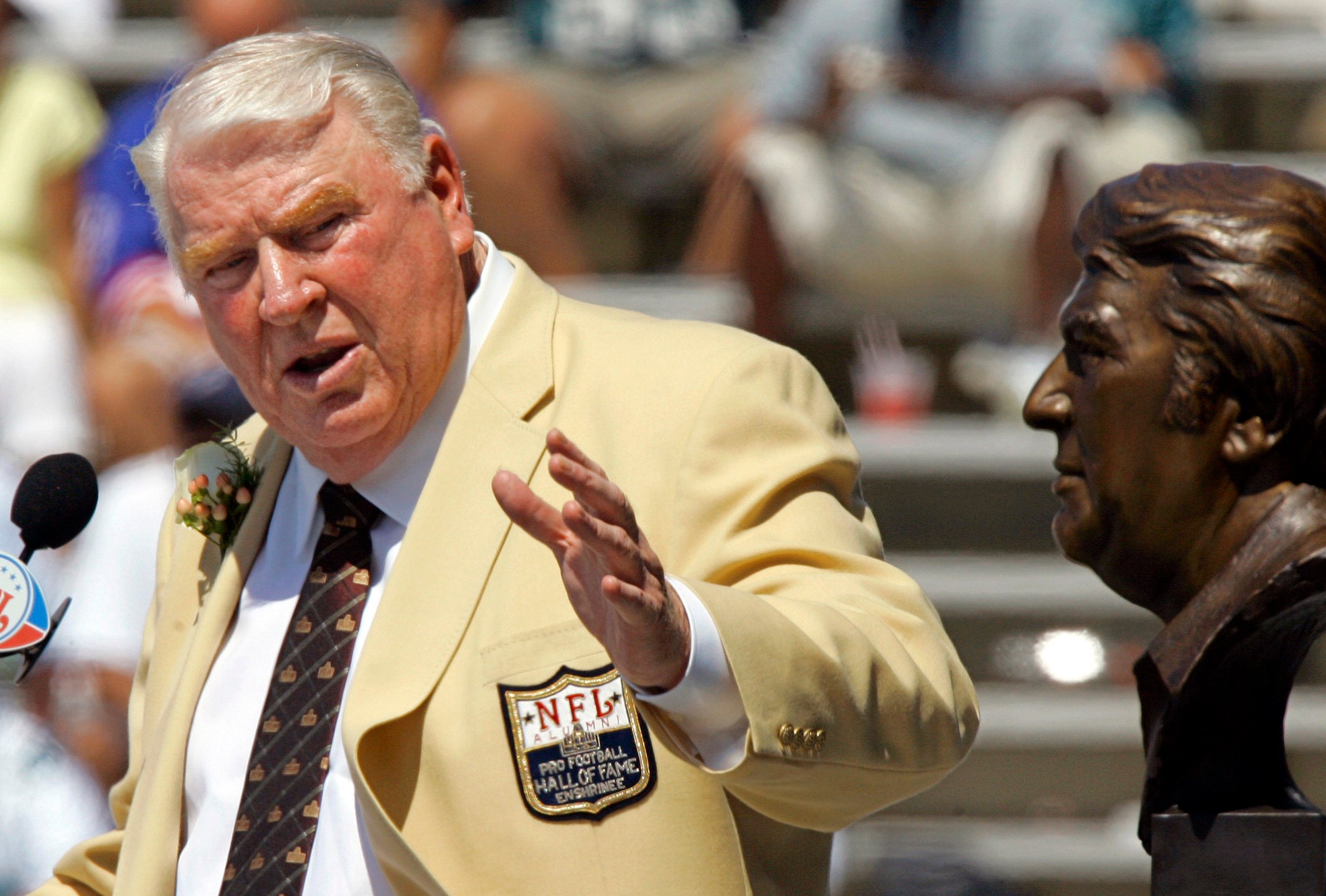 Former Oakland Raiders coach John Madden gestures toward a bust of himself during his enshrinement into the Pro Football Hall of Fame in Canton, Ohio, Aug. 5, 2006. (AP Photo/Mark Duncan, File)