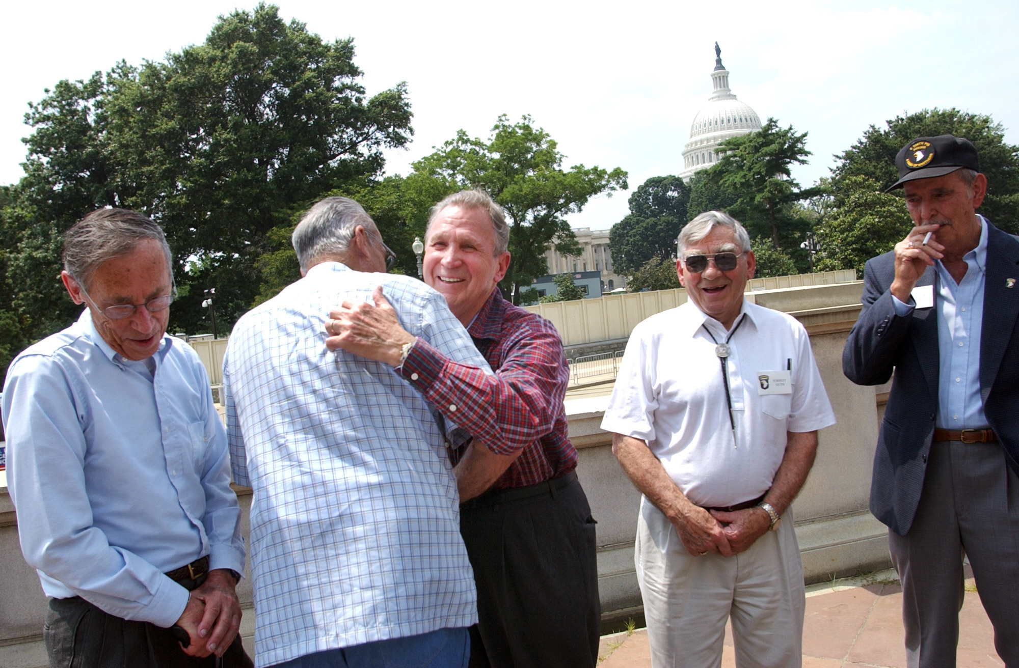 Edward Shames, center, hugs Ed McClung, center left, both members of the World War II Army Company E of the 506th Regiment of the 101st Airborne, with veterans Jack Foley, left, Joe Lesniewski, right, and Shifty Powers, far right, at the Library of Congress in Washington, on July 16, 2003. Shames, who was the last surviving officer of “Easy Company,” which inspired the HBO miniseries and book “Band of Brothers,” has died at age 99. An obituary posted by the Holomon-Brown Funeral Home & Crematory said Shames, of Norfolk, Va., died peacefully at his home on Friday, Dec. 3, 2021. (AP Photo/Gerald Herbert, File)