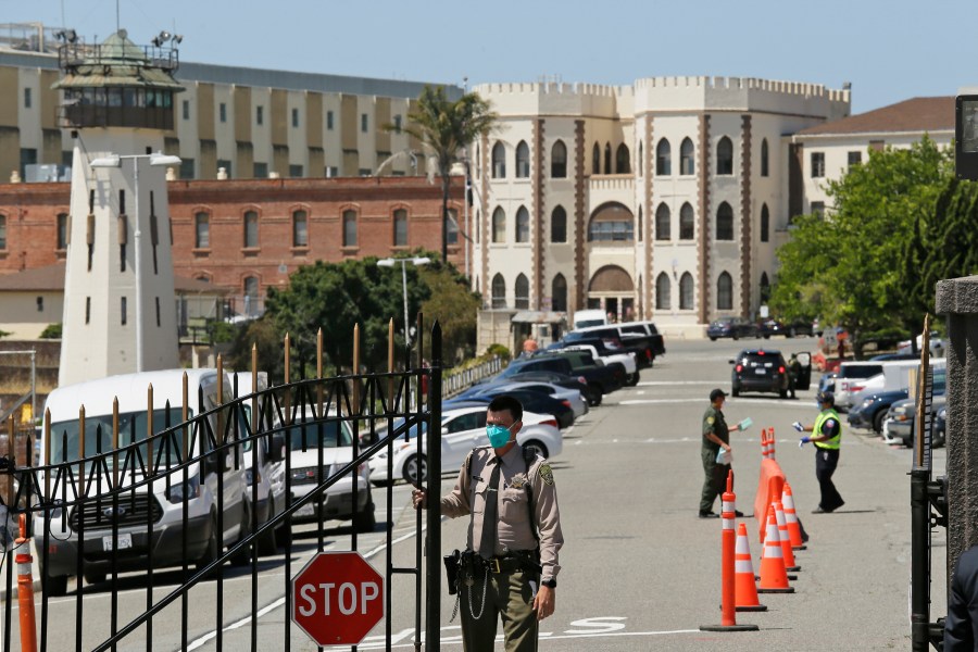 In this July 9, 2020, file photo, a correctional officer closes the main gate at San Quentin State Prison in San Quentin, Calif. A judge on Wednesday, Dec. 29, 2021, temporarily halted California's plans to speed the potential prison release dates for repeat offenders with serious and violent criminal histories under the state's "three strikes" law. (AP Photo/Eric Risberg, File)