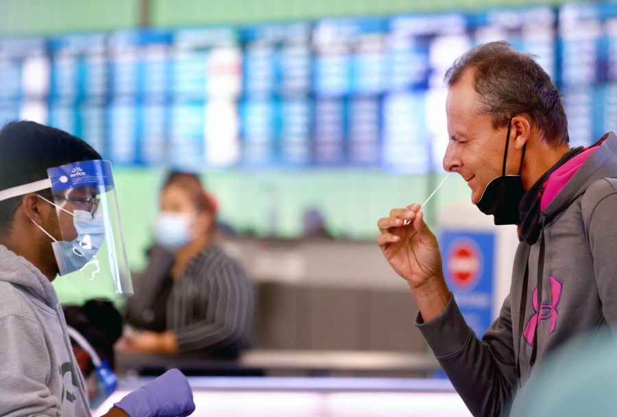 A passenger who arrived from Italy administers a self-collected nasal swab on the first day of a new rapid COVID-19 testing site for arriving international passengers at Los Angeles International Airport (LAX) on Dec. 3, 2021 (Mario Tama/Getty Images)