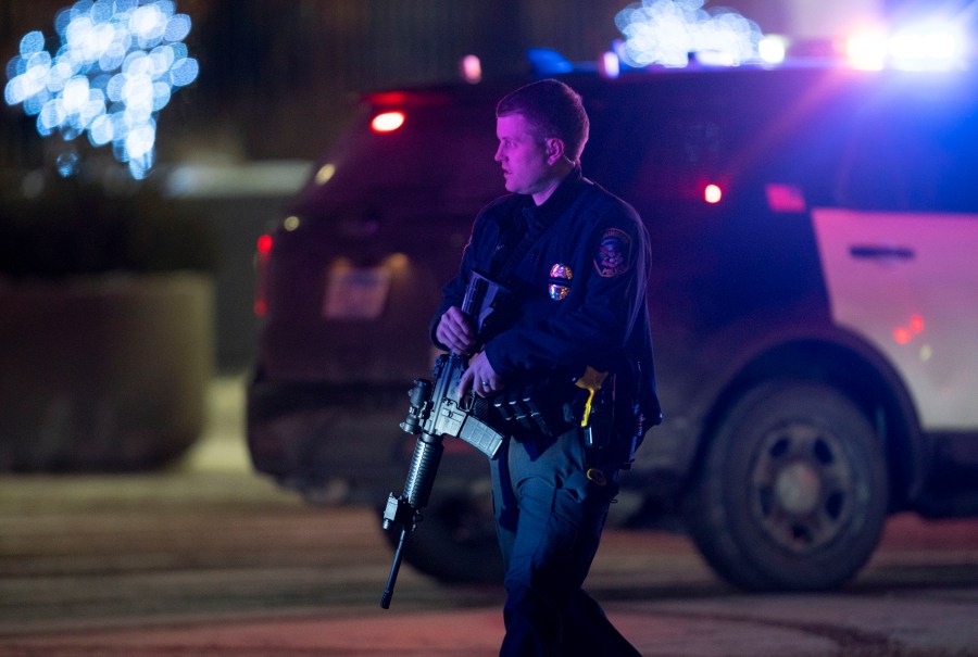 A police officer carrying a rifle exits the Mall of America following a shooting, Friday, Dec. 31, 2021, in Minnesota. Two people were shot and wounded following an apparent altercation at the Mall of America Friday, sending New Year's Eve shoppers scrambling for safety and placing the Minneapolis mall on temporary lockdown, authorities said. (Alex Kormann/Star Tribune via AP)