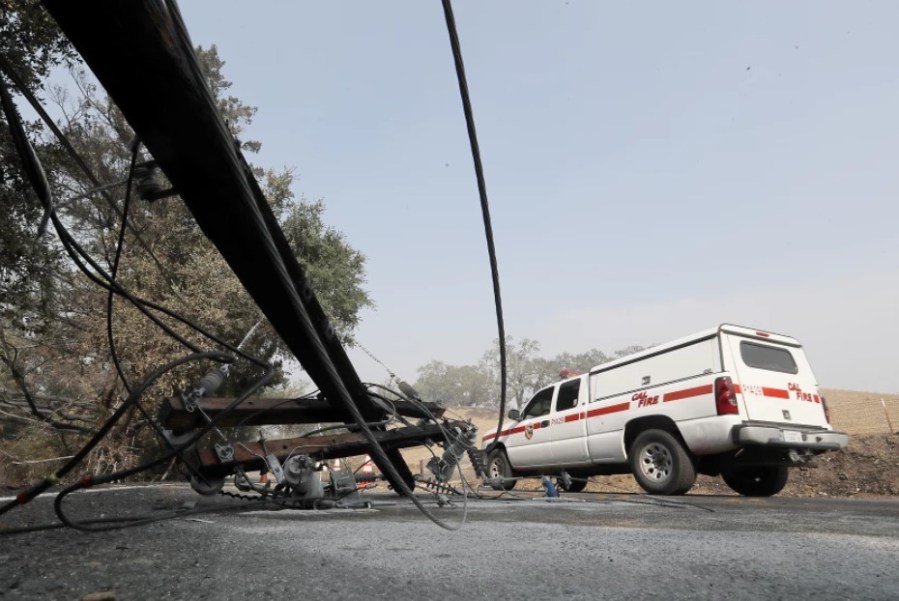 A Cal Fire vehicle drives past a downed power pole in the Alexander Valley two days after the Kincade fire ignited in October 2019.(Luis Sinco/Los Angeles Times)