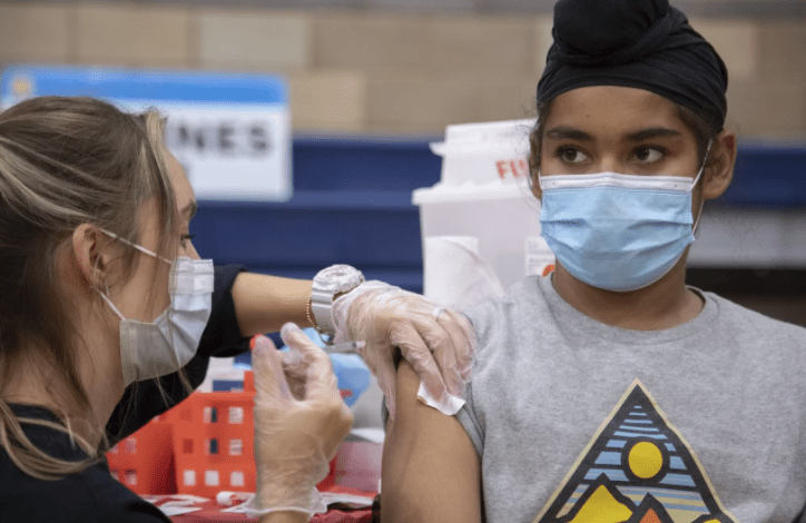 Harnoorvir Singh Jabbal, 11, gets the COVID-19 vaccine from nurse Chelsea Meyer at Arleta High School in November.(Myung J. Chun / Los Angeles Times)