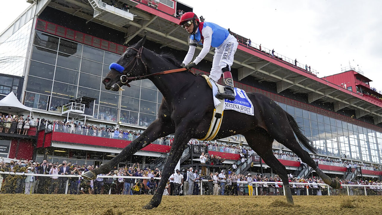 John Velazquez atop Medina Spirit competes during the 146th Preakness Stakes horse race at Pimlico Race Course, Saturday, May 15, 2021, in Baltimore. Kentucky Derby winner Medina Spirit collapsed and died after a workout Monday, Dec. 6, 2021, at Santa Anita. The 3-year-old colt trained by Bob Baffert had just completed five furlongs in his second workout since finishing second in the Breeders’ Cup Classic a month ago at Del Mar, according to Craig Robertson, Baffert’s attorney. (AP Photo/Julio Cortez, File)