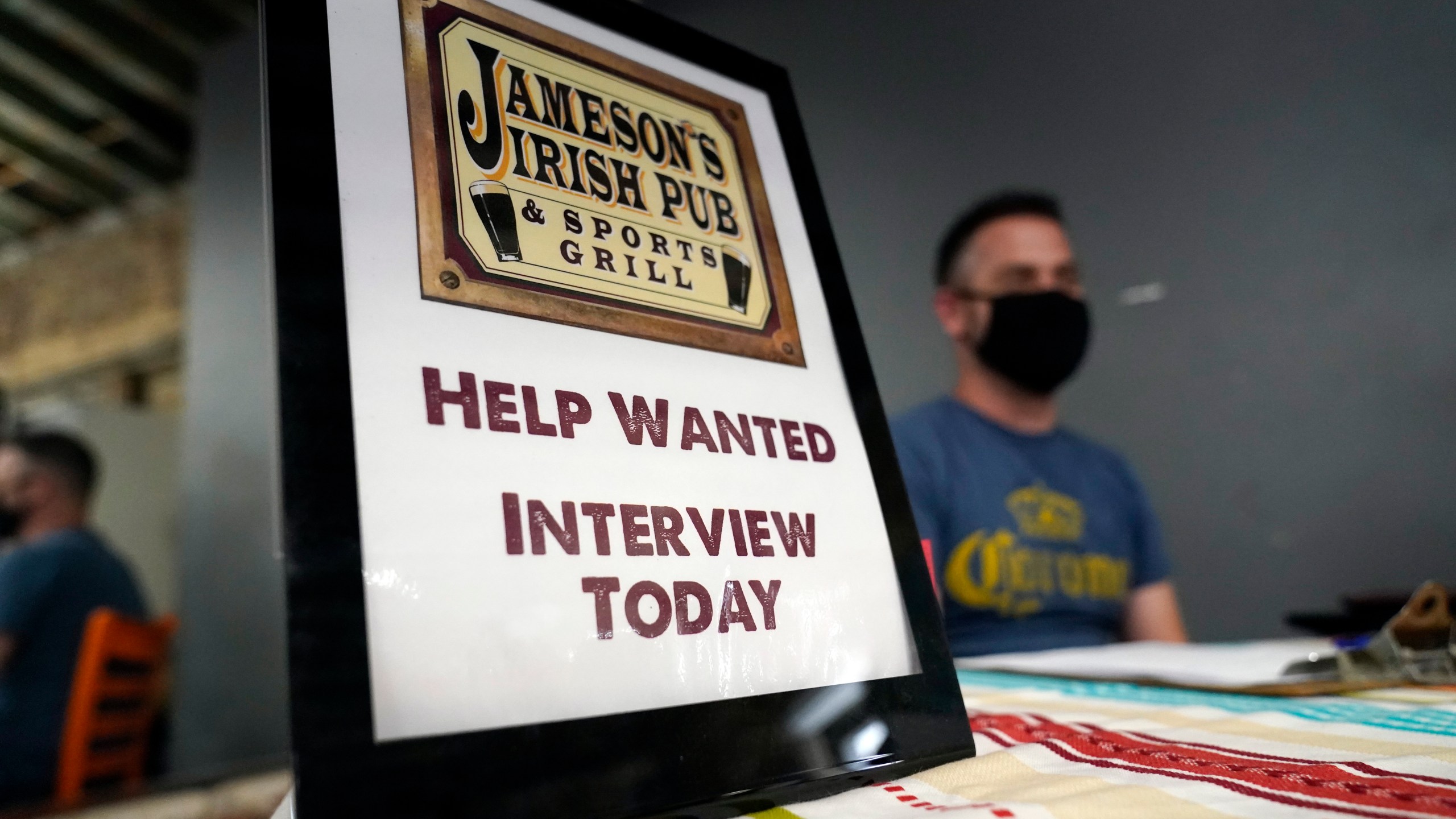 A hiring sign is shown at a booth for Jameson's Irish Pub during a job fair on Sept. 22, 2021, in the West Hollywood section of Los Angeles. Hiring in California slowed significantly in November 2021 even as the state's unemployment rate dipped below 7% for the first time since March 2020, at the start of the pandemic, according to data made public Friday, Dec. 17, 2021. (AP Photo/Marcio Jose Sanchez, File)