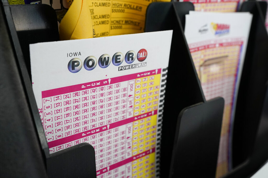 In this Jan. 12, 2021 file photo, blank forms for the Powerball lottery sit in a bin at a local grocery store, in Des Moines, Iowa. (AP Photo/Charlie Neibergall, File)