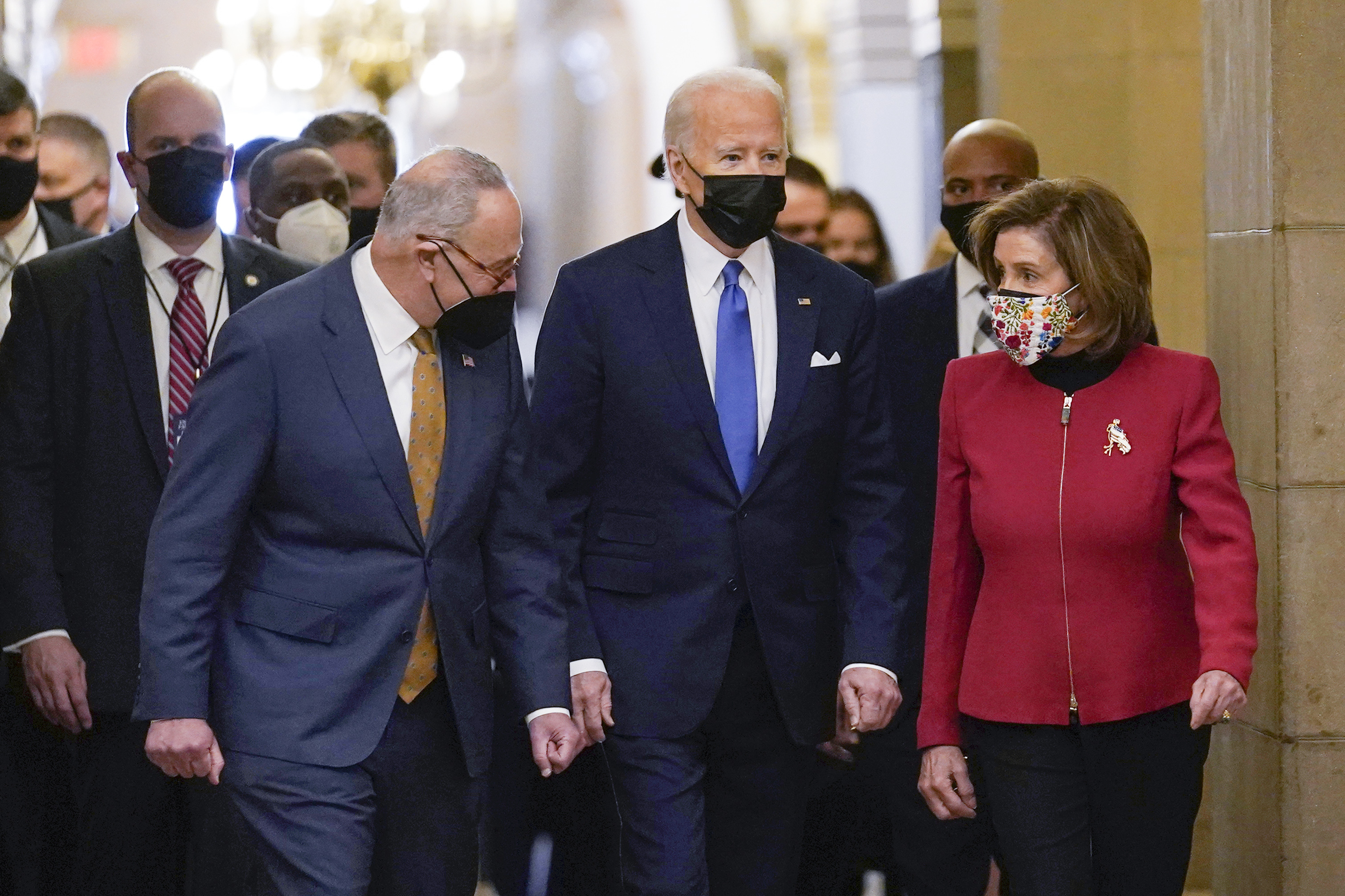 President Joe Biden is flanked by Senate Majority Leader Chuck Schumer of N.Y., left, and House Speaker Nancy Pelosi of Calif., right, after arriving on Capitol Hill in Washington, on Thursday, Jan. 6, 2022. (AP Photo/Susan Walsh)