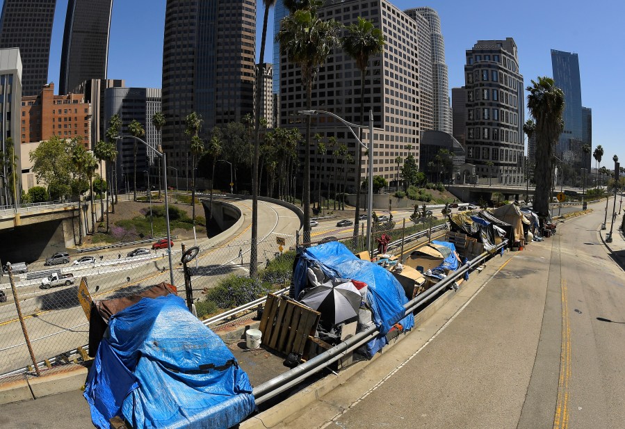 This May 21, 2020, file photo, shows a homeless encampment on Beaudry Avenue as traffic moves along Interstate 110 below during the coronavirus outbreak, in downtown Los Angeles.(AP Photo/Mark J. Terrill, File)