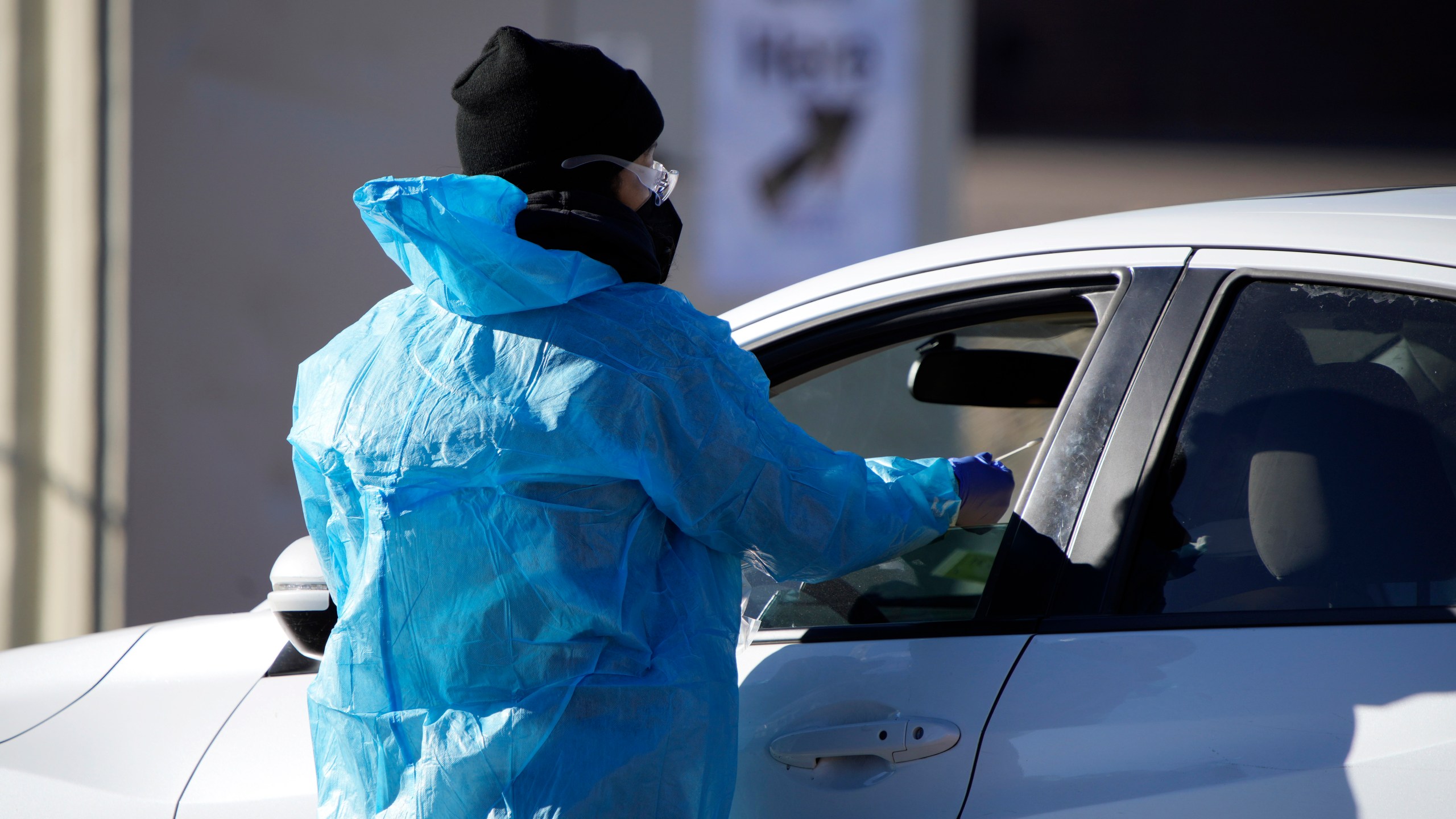 A medical technician performs a nasal swab test on a motorist queued up in a line at a COVID-19 testing site near All City Stadium Dec. 30, 2021, in southeast Denver. (AP Photo/David Zalubowski, File)