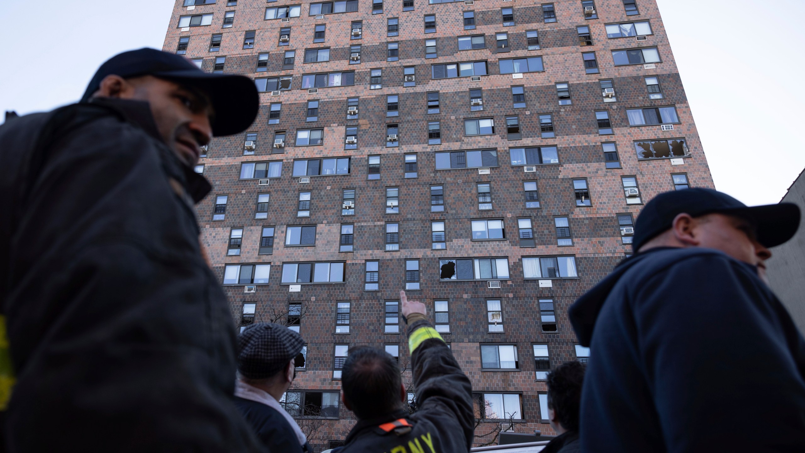 Firefighters work outside the apartment building in the Bronx on Monday, Jan. 10, 2022, in New York. Doctors are working to save the lives of several people gravely injured when smoke from a fire knocked them out or trapped them in their apartments in the New York City high-rise building. (AP Photo/Yuki Iwamura)