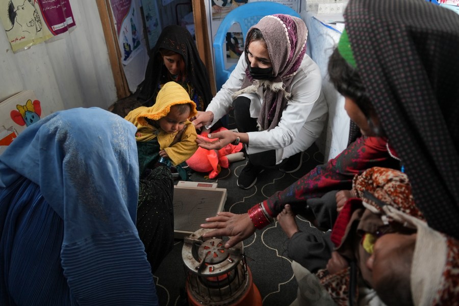 A nurse checks the weight of a child in a makeshift clinic organized by World Vision at a settlement near Herat, Afghanistan, Dec. 16, 2021. In a statement Tuesday, Jan. 11, 2022, the White House announced $308 million in additional humanitarian assistance for Afghanistan, offering new aid to the country as it edges toward a humanitarian crisis since the Taliban takeover nearly five months earlier. (AP Photo/Mstyslav Chernov, File)