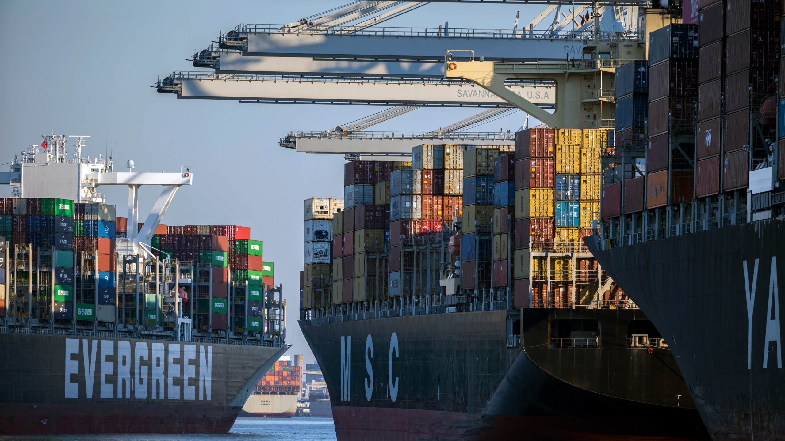 Container ship Ever Far, left, sails down river past the Georgia Ports Authority's Port of Savannah, Wednesday, Sept. 29, 2021, in Savannah, Ga. Inflation has spiked during the recovery from the pandemic recession as Americans have ramped up spending on such items as cars, furniture and appliances. Those increased purchases have clogged ports and warehouses and exacerbated supply shortages of semiconductors and other parts. (AP Photo/Stephen B. Morton)