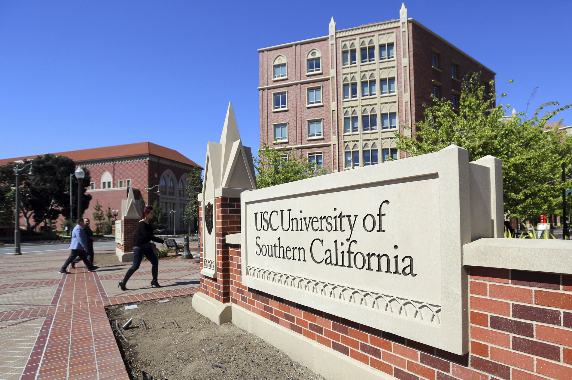 In this March 12, 2019 file photo people walk at the University Village area of the University of Southern California in Los Angeles. (Reed Saxon/Associated Press)