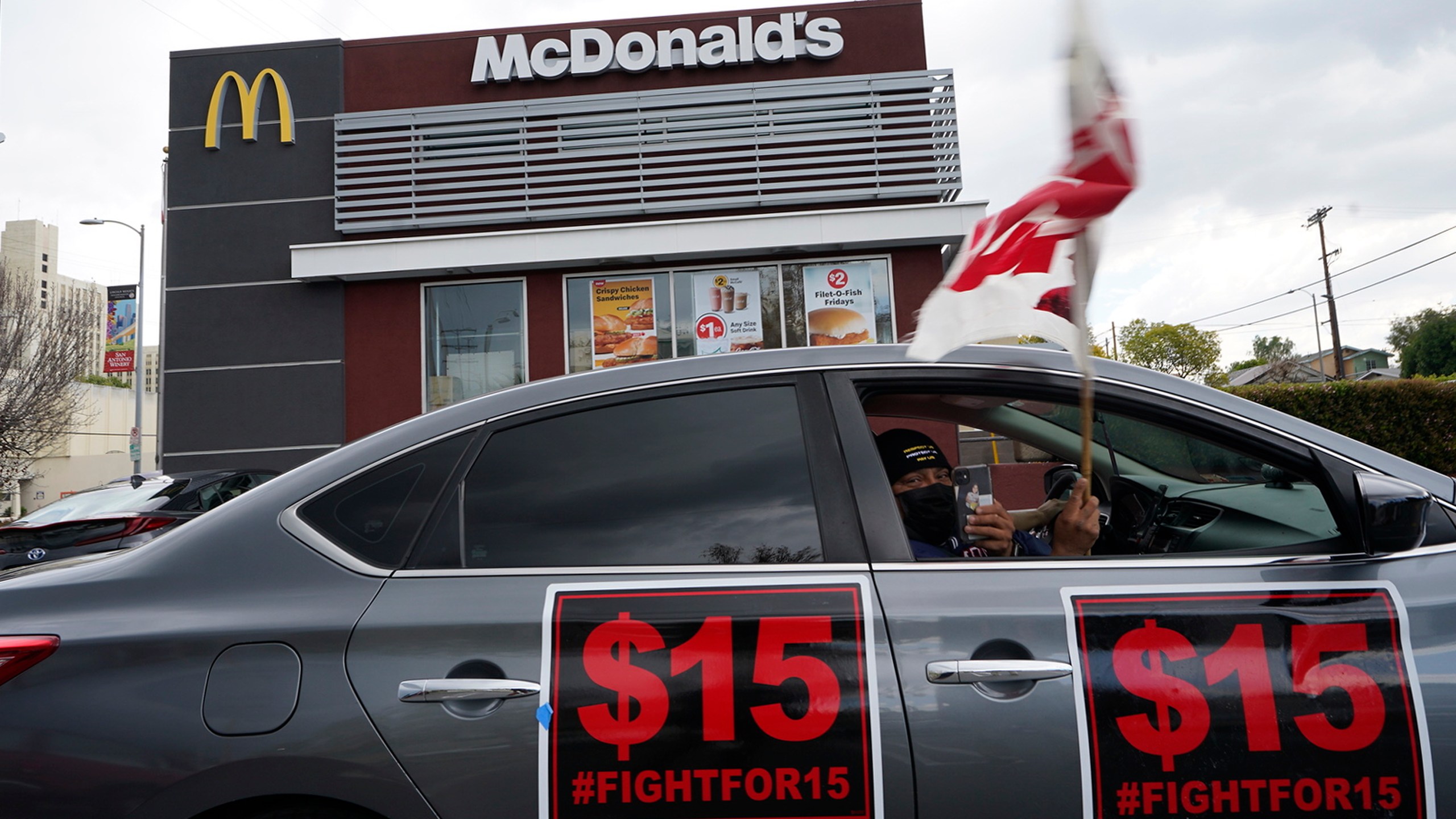 Fast-food workers drive-through to protest for a $15 dollar hourly minimum wage outside a McDonald's restaurant in East Los Angeles Friday, March 12, 2021. On Monday, Jan. 31, 2022 California lawmakers approved a first-in-the-nation measure by Assemblyman Chris Holden that gives California's more than half-million fast food workers increased power and protections. (AP Photo/Damian Dovarganes, File)