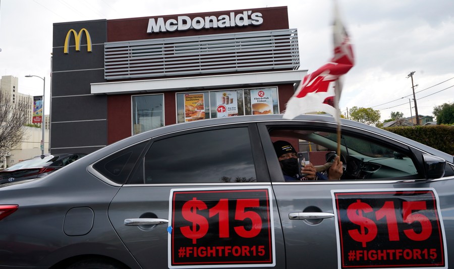 Fast-food workers drive-through to protest for a $15 dollar hourly minimum wage outside a McDonald's restaurant in East Los Angeles Friday, March 12, 2021. On Monday, Jan. 31, 2022 California lawmakers approved a first-in-the-nation measure by Assemblyman Chris Holden that gives California's more than half-million fast food workers increased power and protections. (AP Photo/Damian Dovarganes, File)