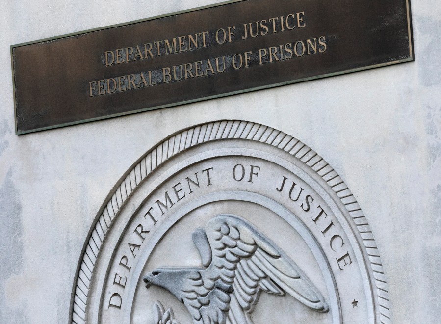 In this July 6, 2020, photo, a sign for the Department of Justice Federal Bureau of Prisons is displayed at the Metropolitan Detention Center in New York. (AP Photo/Mark Lennihan, File)