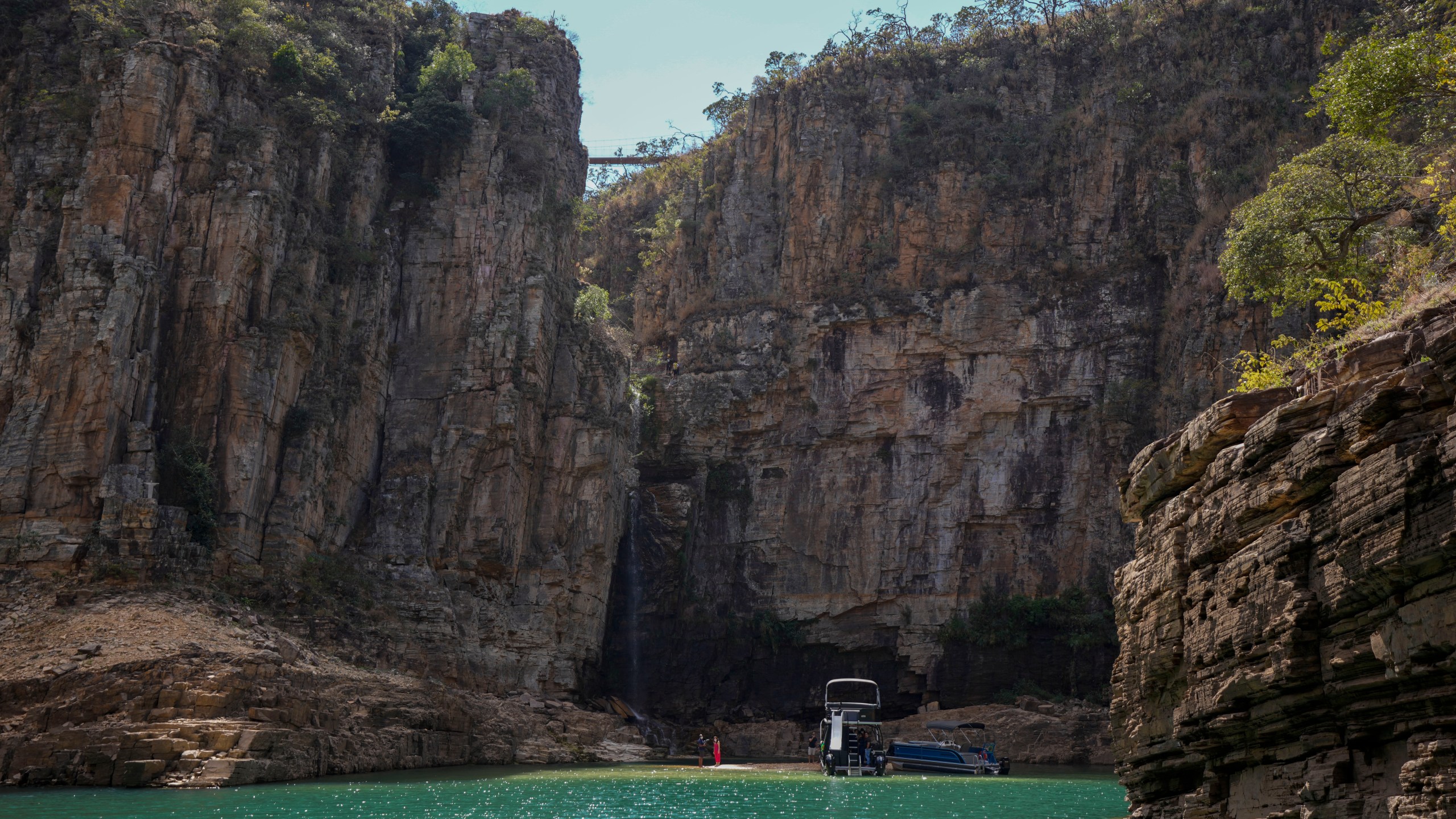 A tourist boat navigates through a canyon in Furnas Lake, near Capitolio City, Brazil, Sept. 2, 2021. A massive slab of rock broke away on Saturday, Jan. 8, 2022, from the canyon wall and and toppled onto pleasure boaters killing at least 10 people and injuring dozens at the popular tourist destination in Minas Gerais state. (AP Photo/Andre Penner)