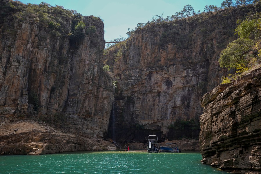 A tourist boat navigates through a canyon in Furnas Lake, near Capitolio City, Brazil, Sept. 2, 2021. A massive slab of rock broke away on Saturday, Jan. 8, 2022, from the canyon wall and and toppled onto pleasure boaters killing at least 10 people and injuring dozens at the popular tourist destination in Minas Gerais state. (AP Photo/Andre Penner)