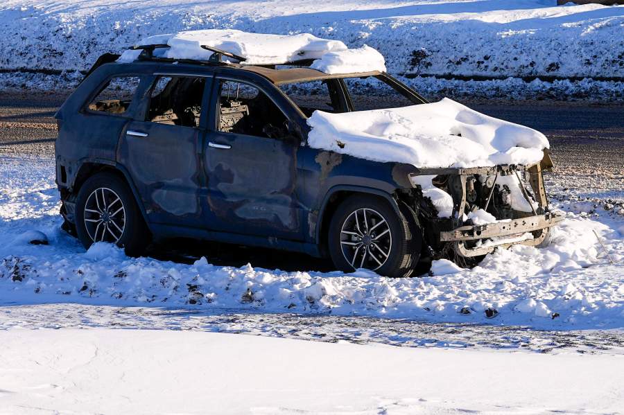 Snow covers the burned remains of a car after wildfires ravaged the area Sunday, Jan. 2, 2022, in Superior, Colo. Investigators are still trying to determine what sparked a massive fire in a suburban area near Denver that burned neighborhoods to the ground and destroyed nearly 1,000 homes and other buildings. (AP Photo/Jack Dempsey)