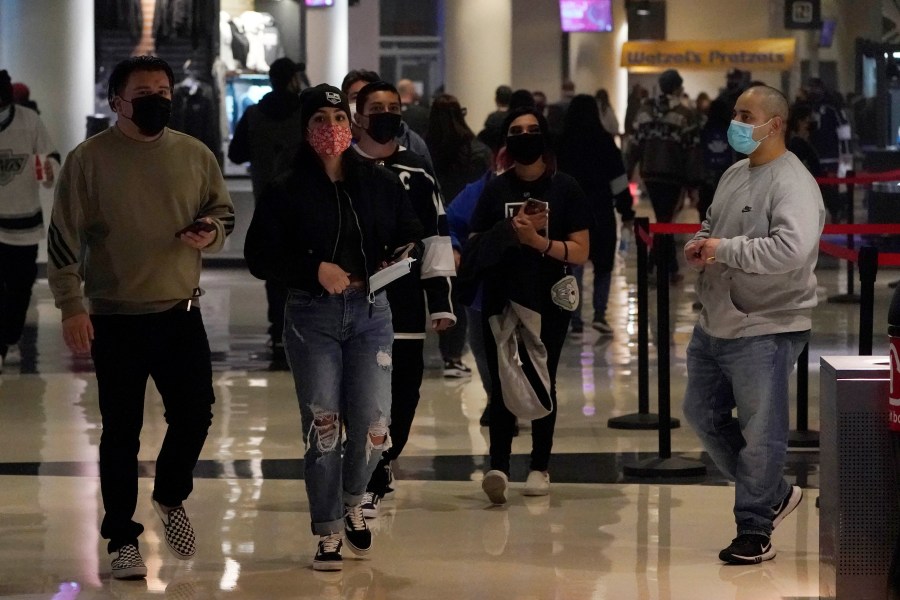 Fans wear masks as they walk inside crypto.com Arena before an NHL hockey game between the Los Angeles Kings and the Nashville Predators Thursday, Jan. 6, 2022, in Los Angeles. (AP Photo/Marcio Jose Sanchez)