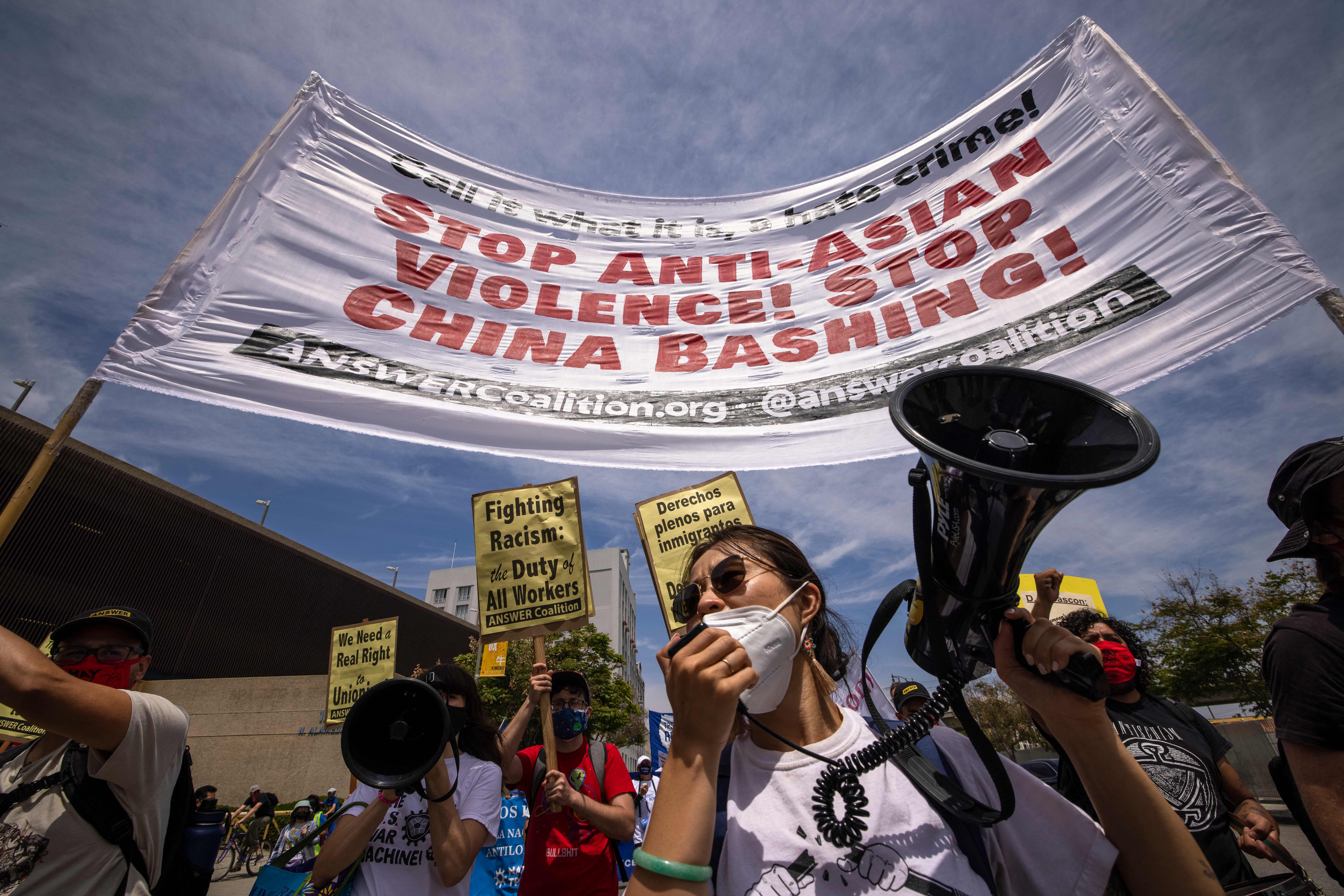 A woman protests anti-Asian violence and hatred as a coalition of activist groups and labor unions participate in a May Day march for workers' and human rights in Los Angeles on May 1, 2021. (DAVID MCNEW/AFP via Getty Images)