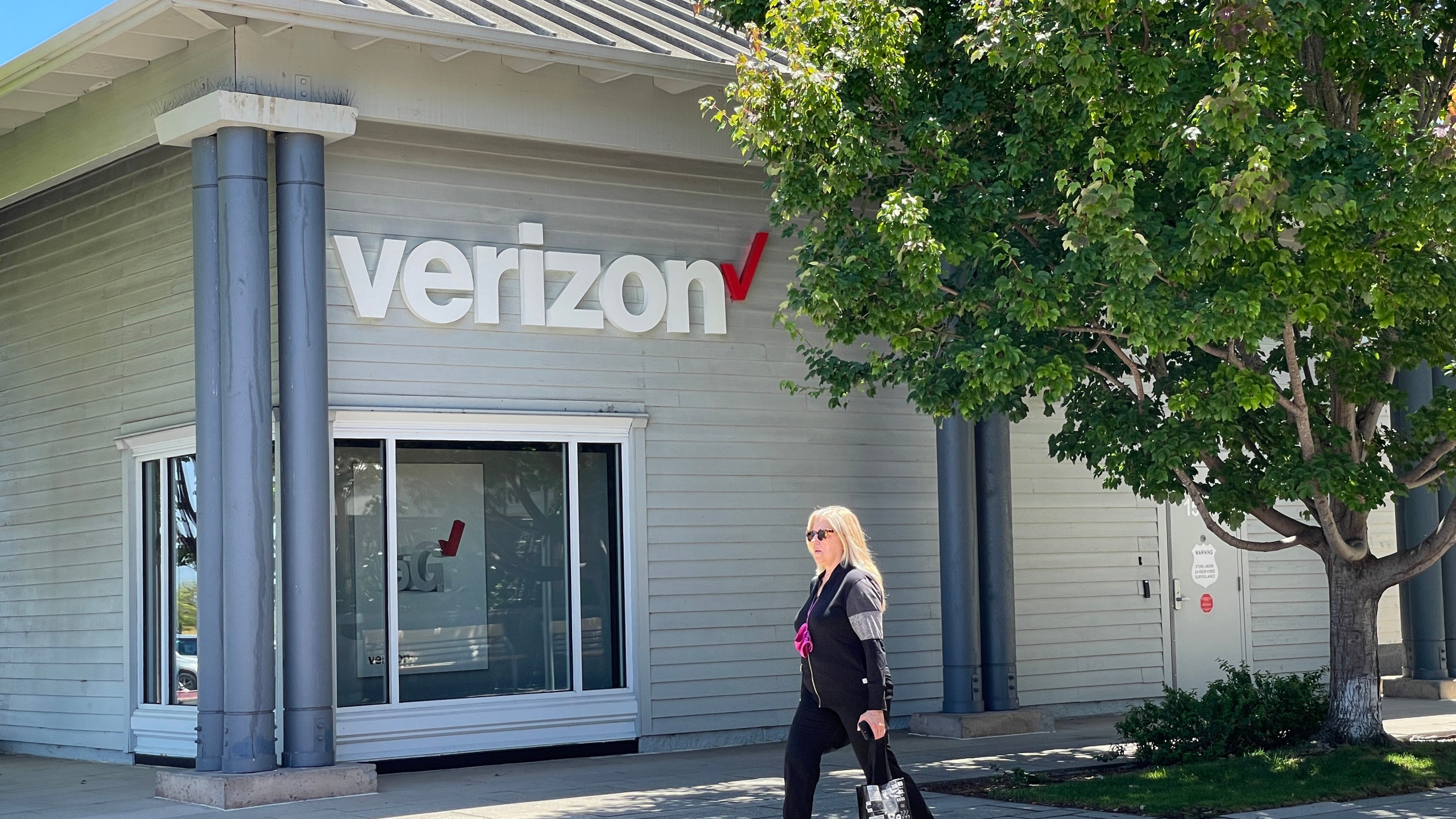 A pedestrian walks by a Verizon store on July 21, 2021 in Corte Madera, California. ( Justin Sullivan/Getty Images)