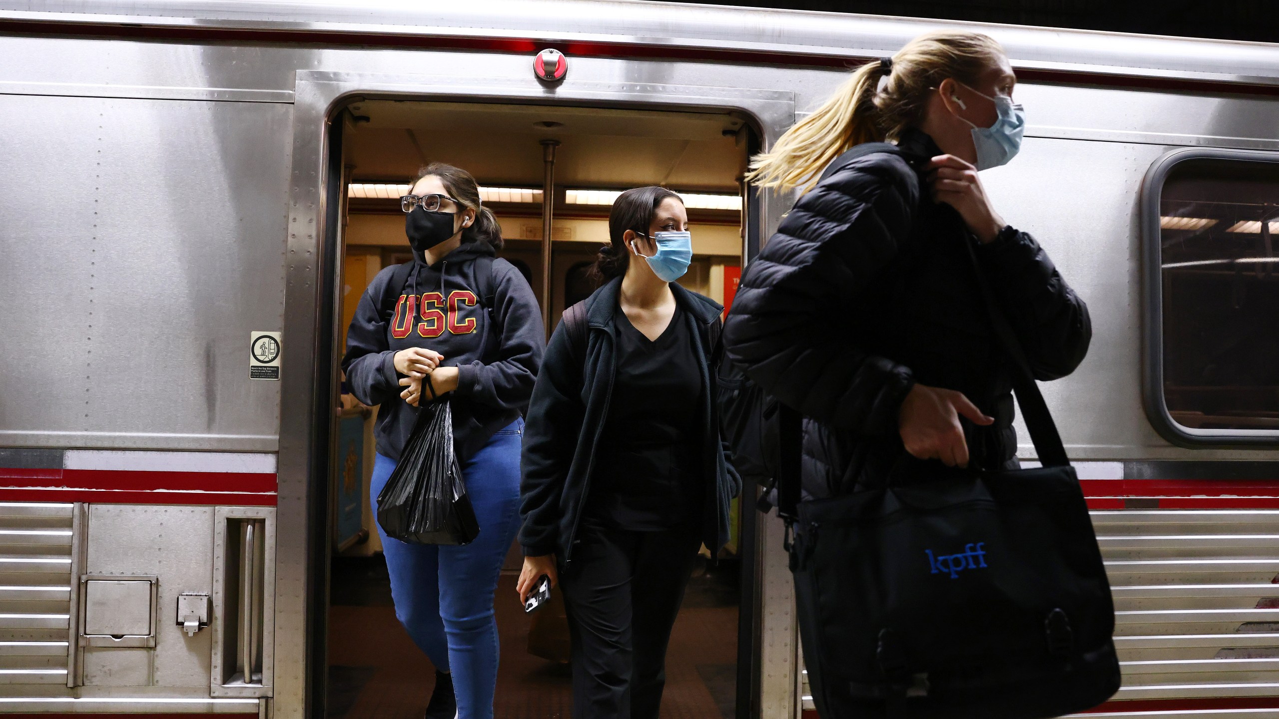 People wear face coverings while departing a Los Angeles Metro Rail train on Dec. 15, 2021. (Mario Tama/Getty Images)