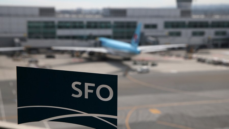 A plane parked at the international terminal is seen through the window of a sky train station at San Francisco International Airport on March 13, 2015 in San Francisco. (Justin Sullivan/Getty Images)