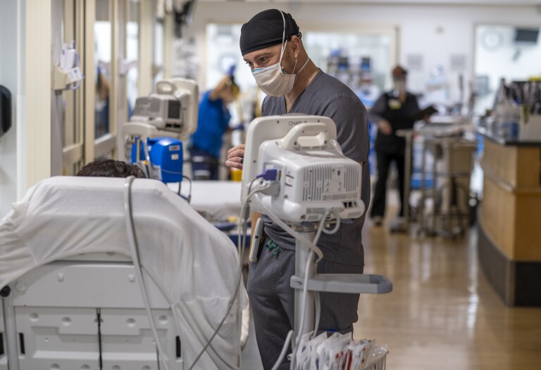 Dr. Leo Rodriguez speaks to a patient in the emergency department at Providence Little Company of Mary Medical Center in Torrance on Jan. 11, 2022. (Francine Orr / Los Angeles Times)