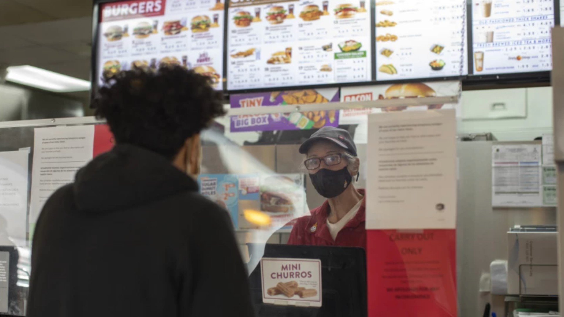 A complaint filed by four workers at fast-food chain Jack in the Box alleges management at a location in Folsom dissuaded workers who reported feeling sick from quarantining and allowed them to work without masks. Above, an employee serves a customer at another location. (Myung J. Chun / Los Angeles Times)