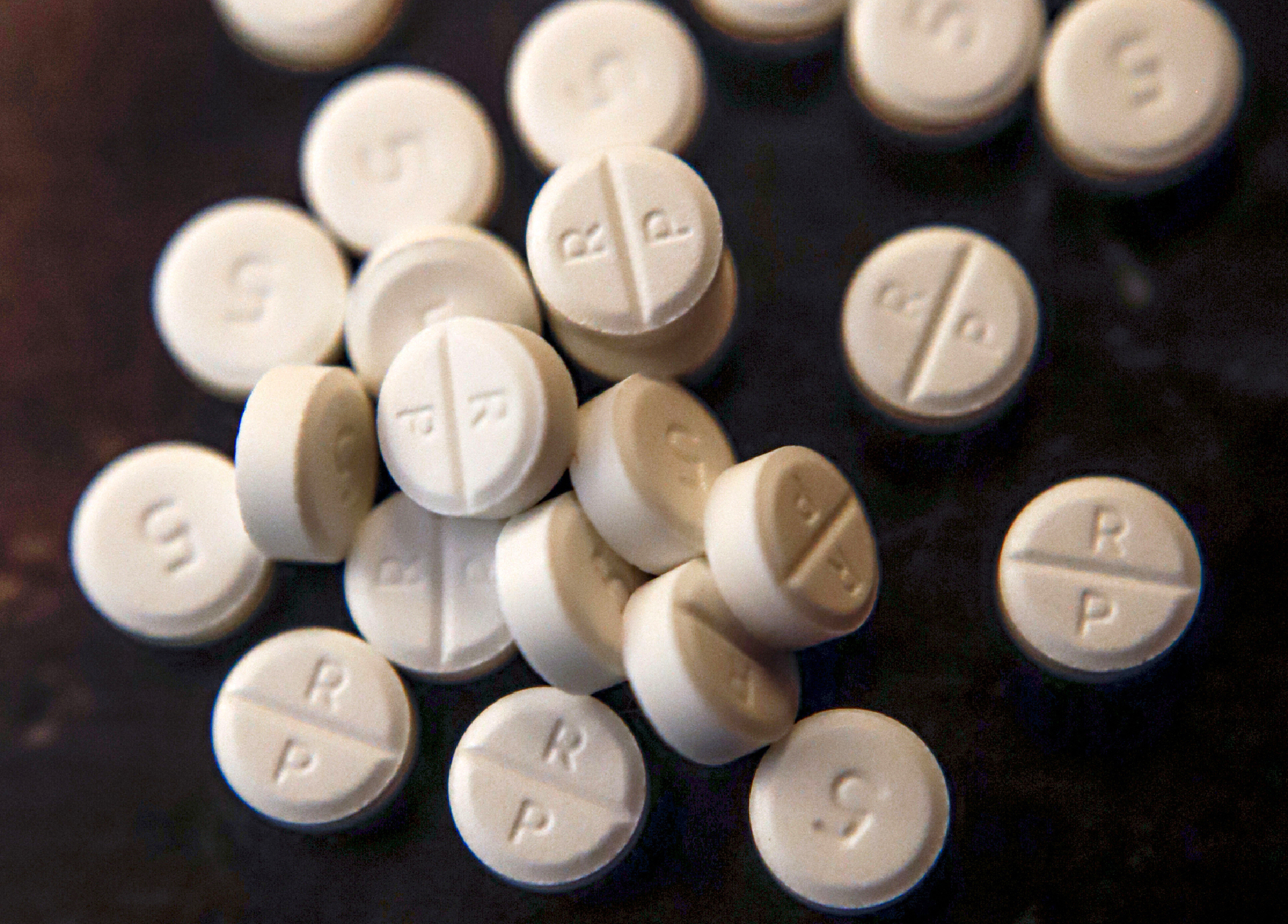 This June 17, 2019, file photo shows 5-mg pills of Oxycodone. Native American tribes in the U.S. have reached settlements worth $590 million over opioids. A court filing made Tuesday, Feb. 1, 2022 in Cleveland lays out the details of the settlements with drugmaker Johnson & Johnson and distribution companies AmerisoruceBergen, Cardinal Health and McKesson. (AP Photo/Keith Srakocic, File)