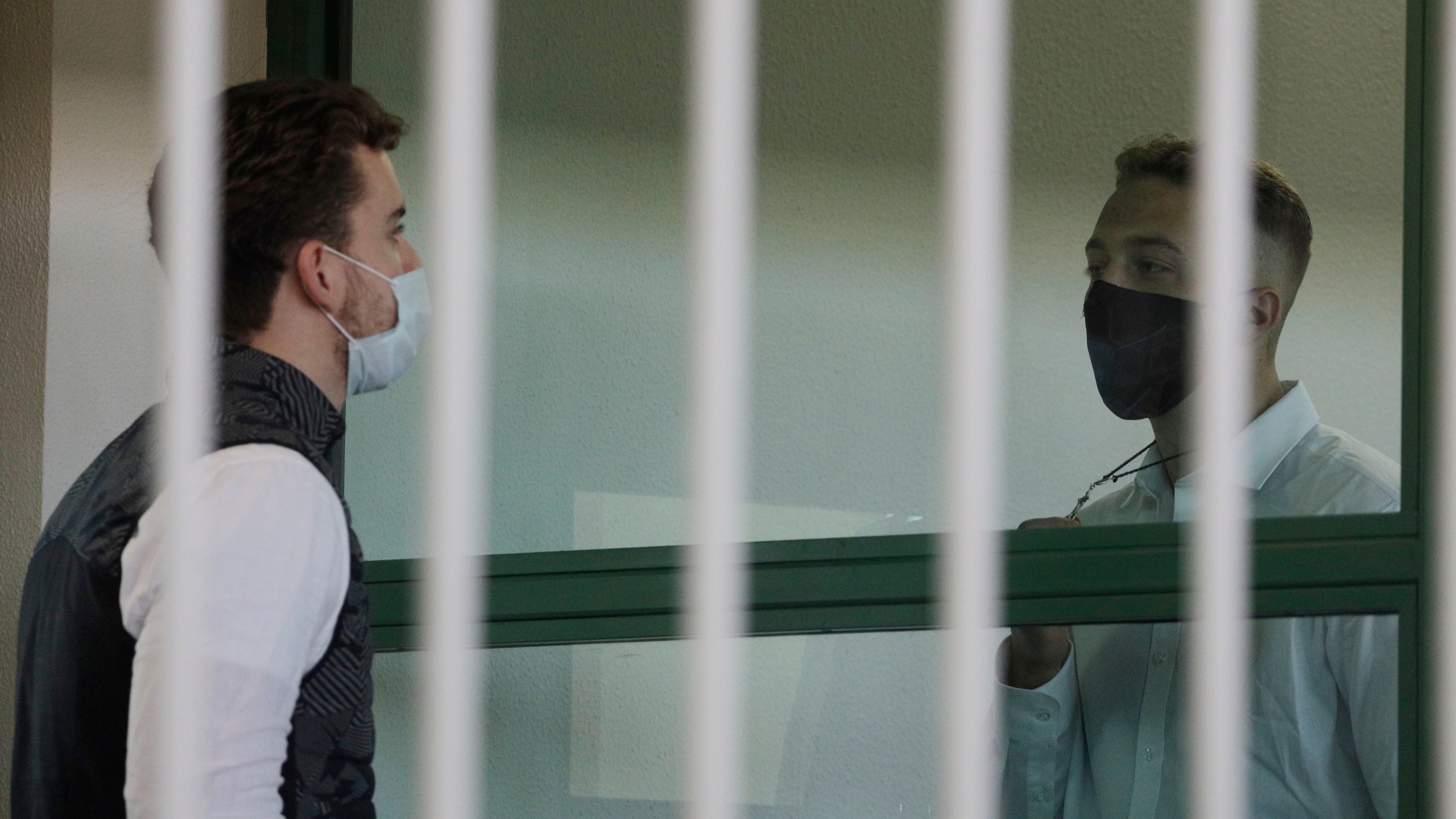 Finnegan Lee Elder, right, shows a crucifix to co-defendant Gabriel Natale-Hjorth before a jury began deliberating their fate on May 5, 2021. (Gregorio Borgia/Associated Press)