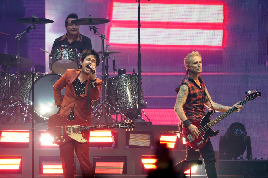 Billie Joe Armstrong, left, Mike Dirnt, right, and Tre' Cool, top left, of the band Green Day perform on day three of the Bud Light Super Bowl Music Fest, Saturday, Feb. 12, 2022, at Crypto.com Arena in Los Angeles. (AP Photo/Chris Pizzello)