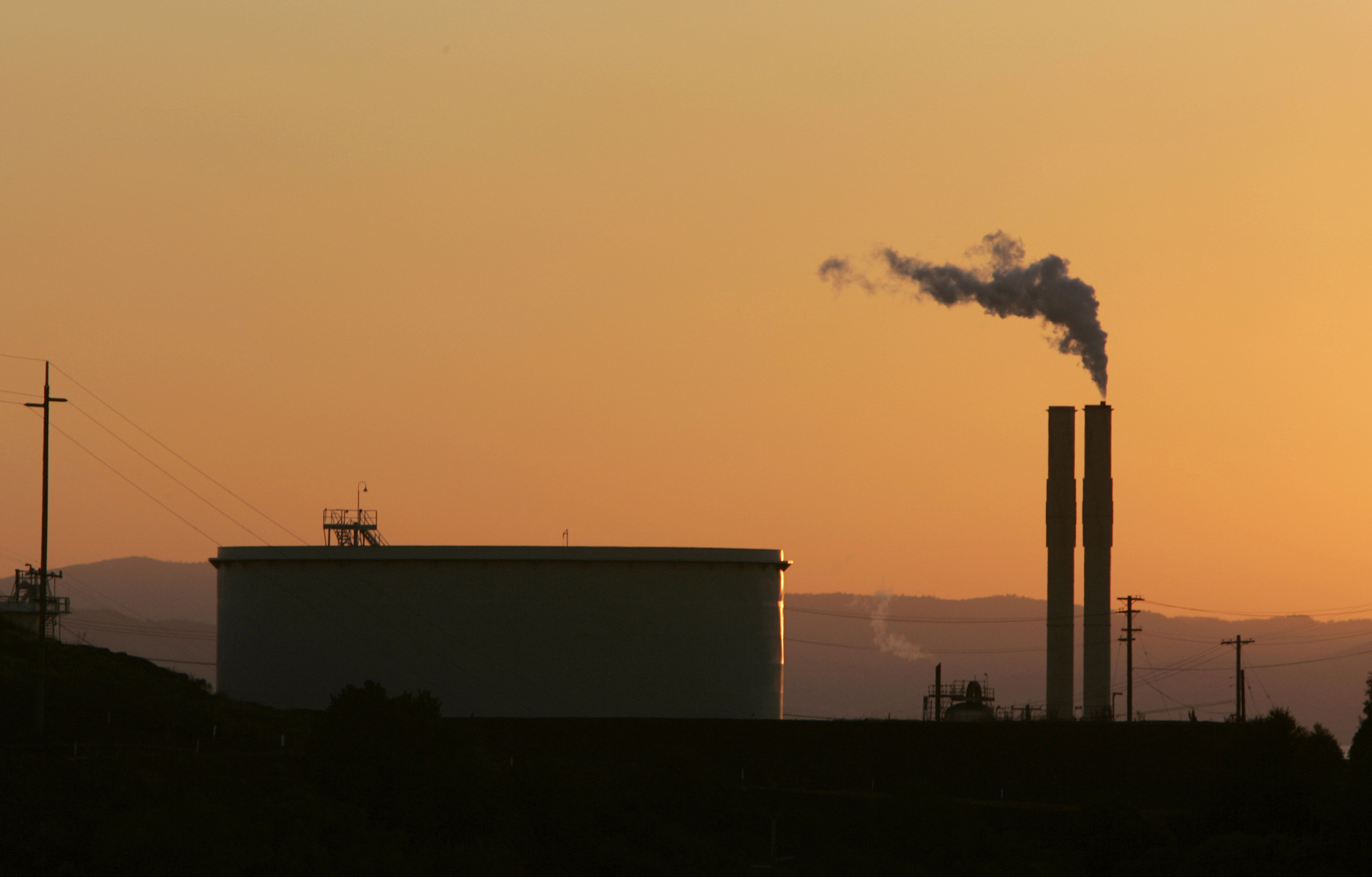 In this Friday Sept. 22, 2006 file photo, an oil refinery is seen at sunset in Rodeo, Calif. Oil refineries, electric utilities and other emitters of greenhouse gases must pay to emit carbon dioxide under the state's cap-and-trade program. But the companies in California that participate in the program have saved up to 321 million pollution allowances. A panel of experts says that could jeopardize the states' ability to meet its emissions reduction goals, according to a new report, finalized on Wednesday Feb. 9, 2022. (AP Photo/Rich Pedroncelli, file)