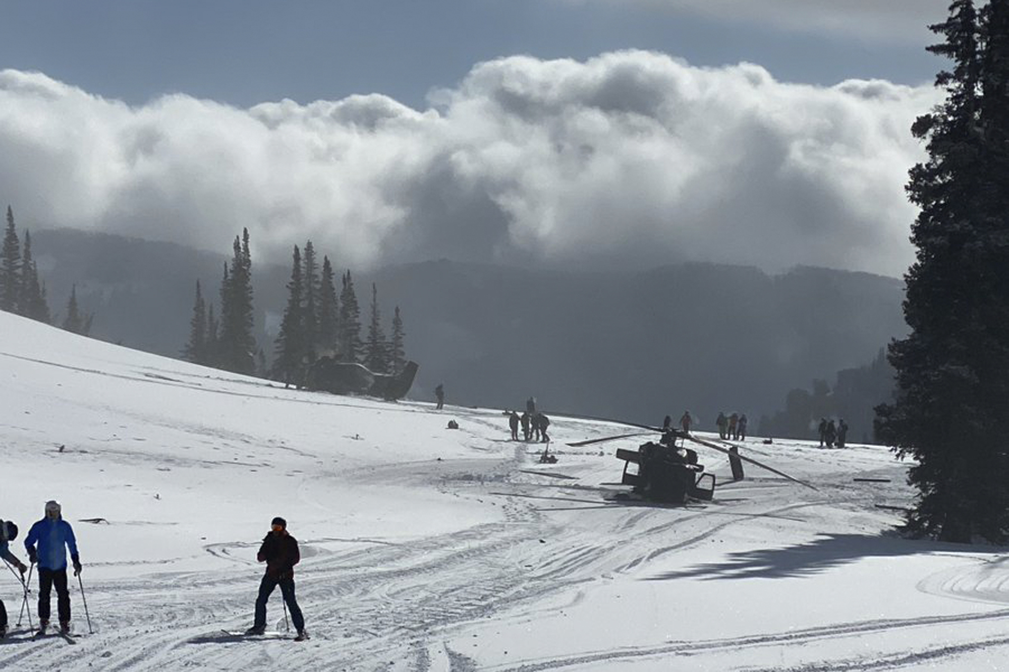 In this photo provided by @LifterMike93 is the scene where a pair of Utah National Guard helicopters were involved in an accident near Snowbird Ski Resort in Snowbird, Utah on Tuesday, February 22, 2022. The helicopters crashed near the ski resort during a Utah National Guard training exercise. No crew members were hurt, but both helicopters were damaged. (@LifterMike93 via AP)