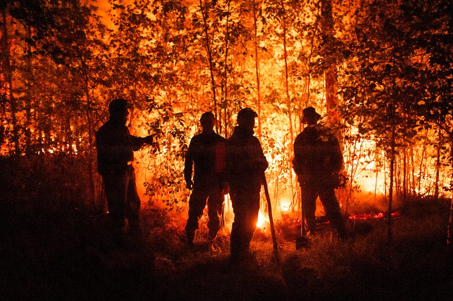 Firefighters work at the scene of forest fire near Kyuyorelyakh village at Gorny Ulus area, west of Yakutsk, in Russia Thursday, Aug. 5, 2021. A warming planet and land use changes mean more wildfires will scorch large parts of the globe in coming decades. That's according to a UN report released Wednesday, Feb. 23, 2022 that says many governments are ill-prepared to address the problem. (AP Photo/Ivan Nikiforov, File)